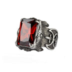 Stainless steel ring with large red, faceted stone and lily ax on the sides, Width: approx. 2.3 cm, Material: stainless steel with faceted zirconia.