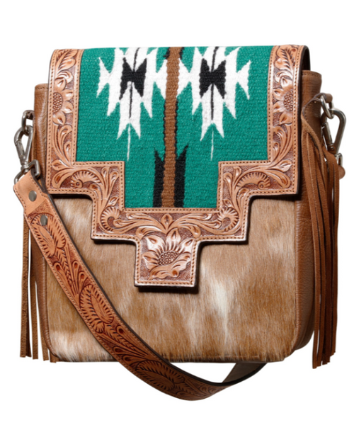 A boho style shoulder bag with hand-punched cowhide design, featuring turquoise textile inserts and fringing, with a detachable shoulder strap.