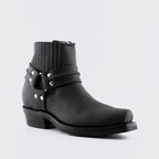 Premium Black Leather Western Ankle Boots with Harness. Discover the iconic Renegade Lo Western ankle boots, a perfect fusion of classic cowboy style and modern rock edge. These premium black leather boots feature distinctive harness straps, slip-on convenience, and versatile unisex styling that works for both men and women who appreciate authentic Western aesthetics with contemporary attitude.